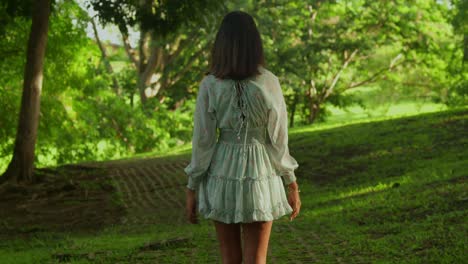 una joven con cabellos rizados pasa un día feliz caminando en un parque tropical en la isla de trinidad