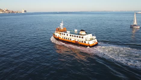 drone shot flying alongside the famous river boat to lisbon, over the river tejo, in portugal.
