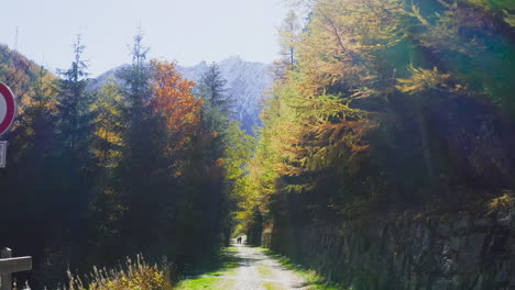 a ghost street in the mountains with the sign of no entry, where a couple is walking.