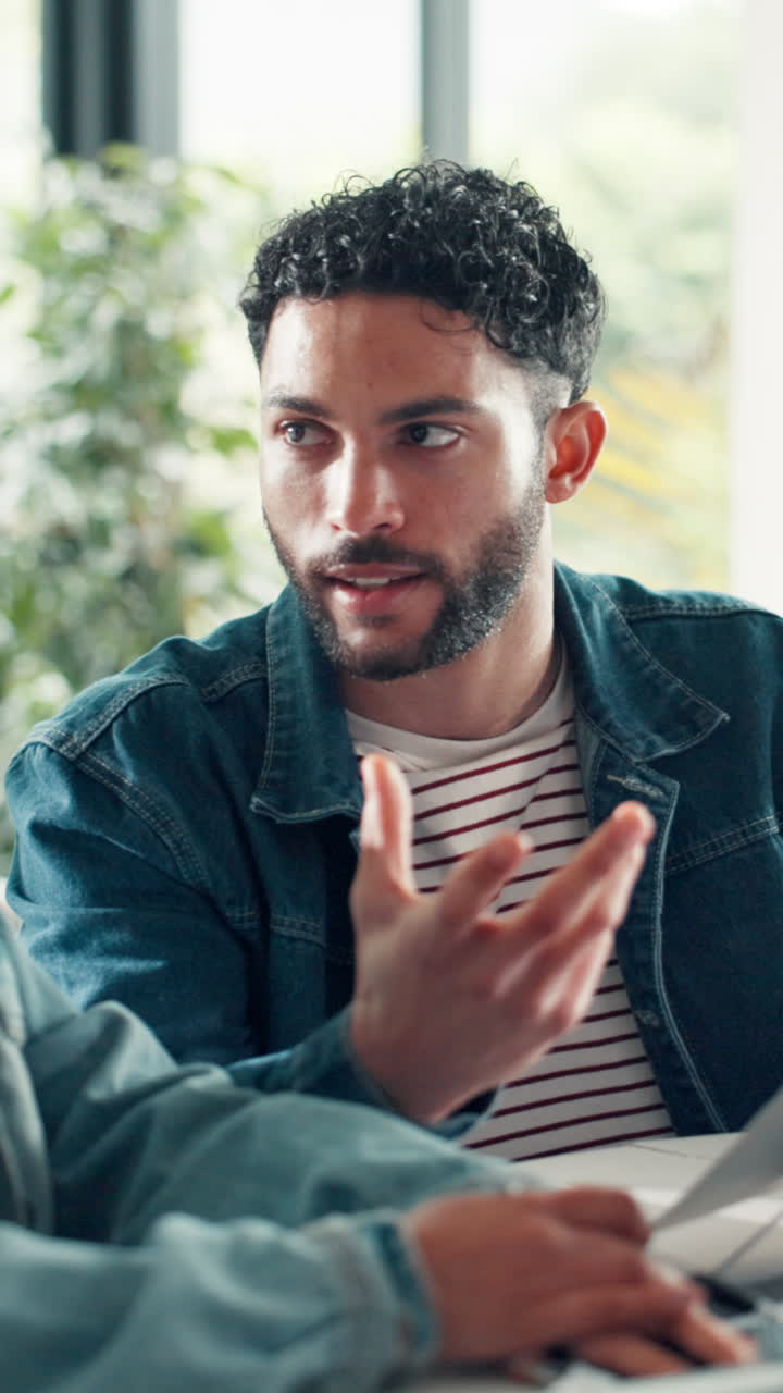 Giovane uomo che esamina documenti e discute idee in un ambiente informale