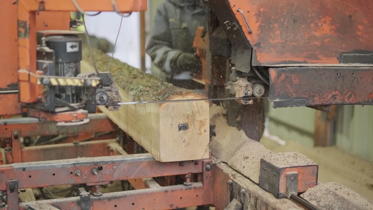 Sagbruksmaskin kutter stor tømmerstokk til trelast