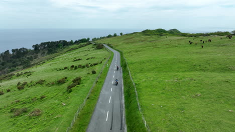 bikers ride on remote countryside road in spain, aerial drone view