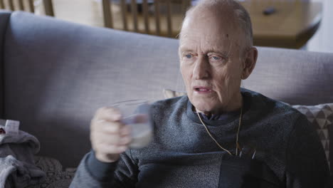 elderly man drinking milk on couch