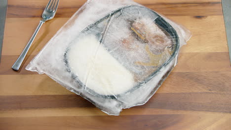 trozo de hielo congelado en un recipiente de caja lleno de comida saludable, en la mesa del comedor