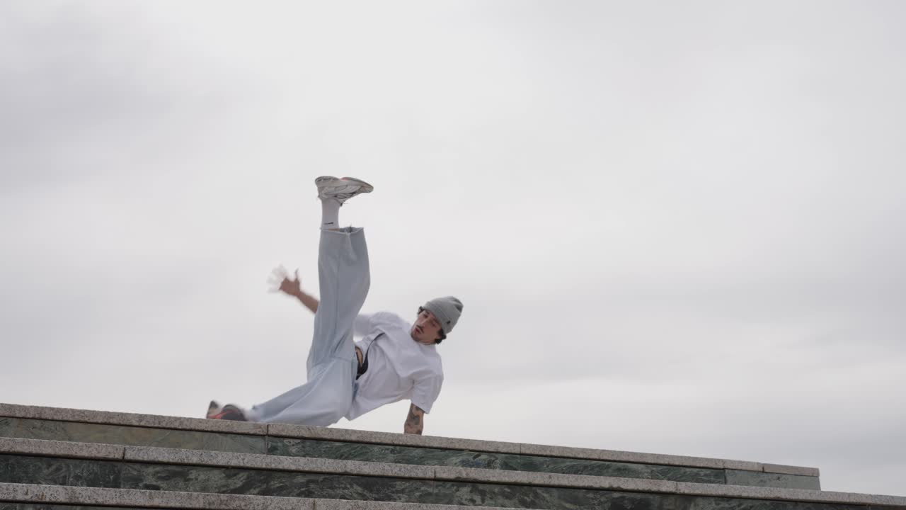 Breakdancer performing acrobatics on urban rooftop