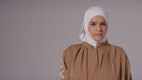 Studioporträt-Einer-Lächelnden-Muslimischen-Frau-Mit-Hijab-Vor-Schlichtem-Hintergrund-2