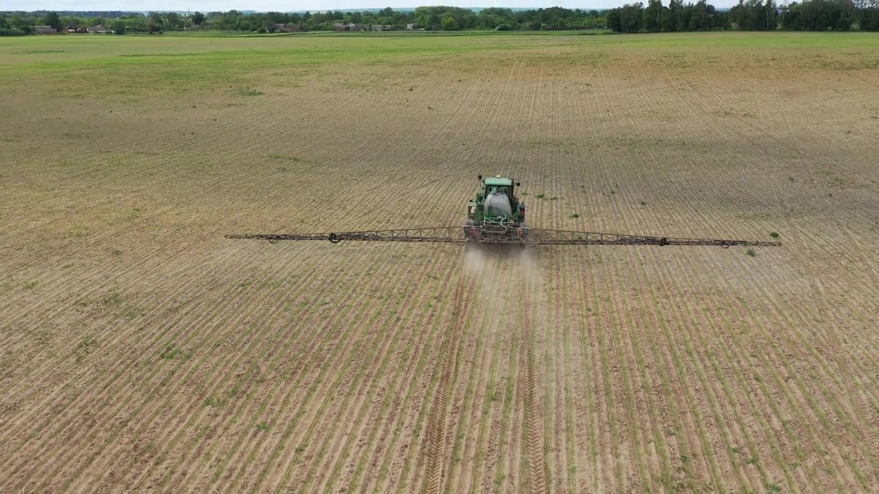 Trattore che irrora fertilizzante su un campo agricolo