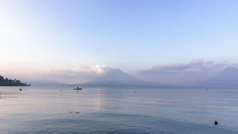 timelapse del lago atitlán en guatemala durante el amanecer con el hombre pescando en primer plano