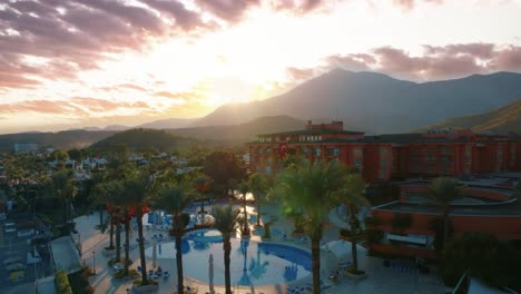 sunset over a turkish resort hotel with pool