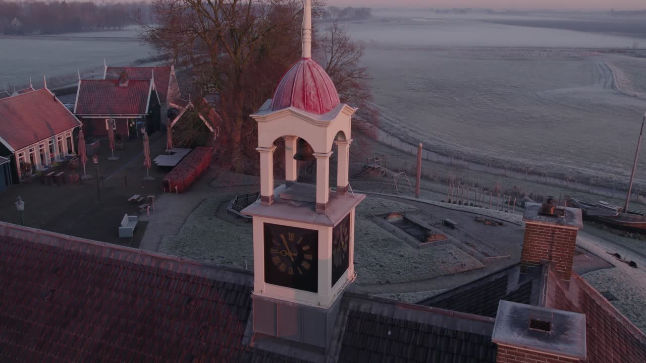 Luftfoto af landsby med kirke og træer badet i morgenlys, Schokland