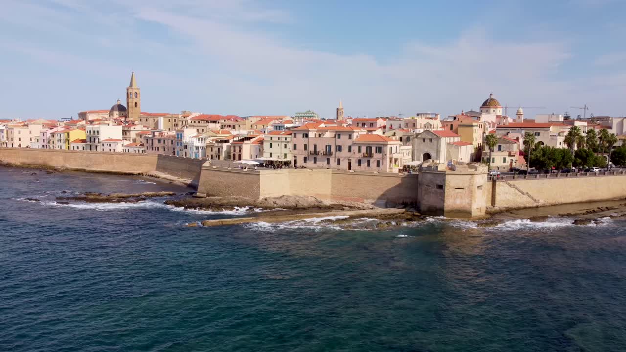 clip de las olas del océano aplastando las rocas y los muros del castillo medieval de la ciudad de alghero en cerdeña, italia