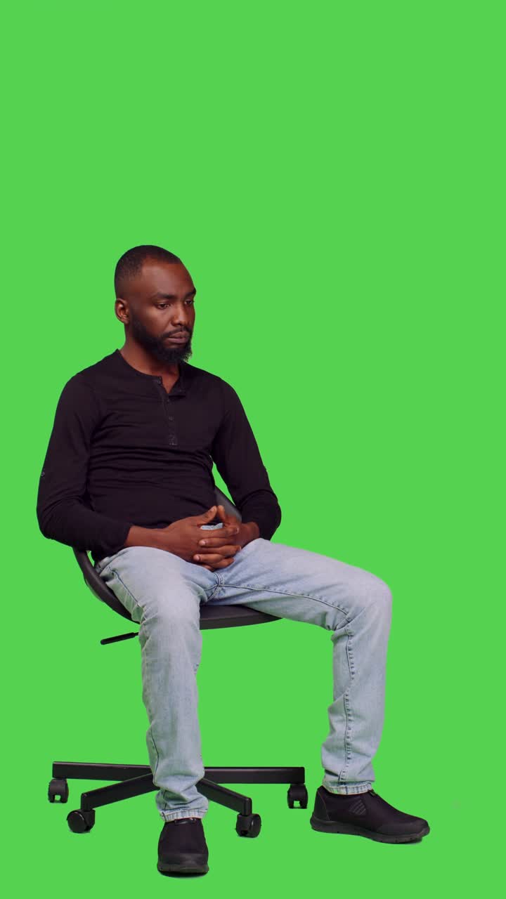 Video verticale: vista laterale di persona afroamericana seduta su una sedia in attesa
