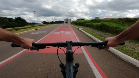 cyclist on urban bike path with safety signs, pov