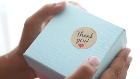 hands holding a thank you gift box