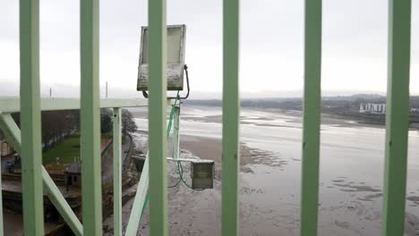 barandillas de seguridad industrial valla barrera closeup con vistas a la marea baja frente al mar desde el puente alto ver dolly lento a la izquierda