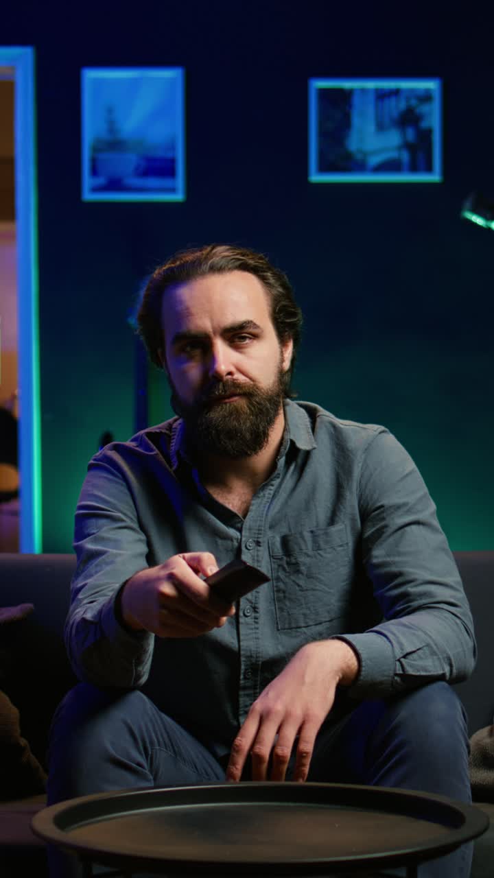 Vertical video Bored person on couch in front of TV zapping though channels