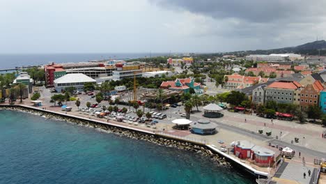 pan across promenade on sunny day as tourists roam vibrant city of willemstad curacao