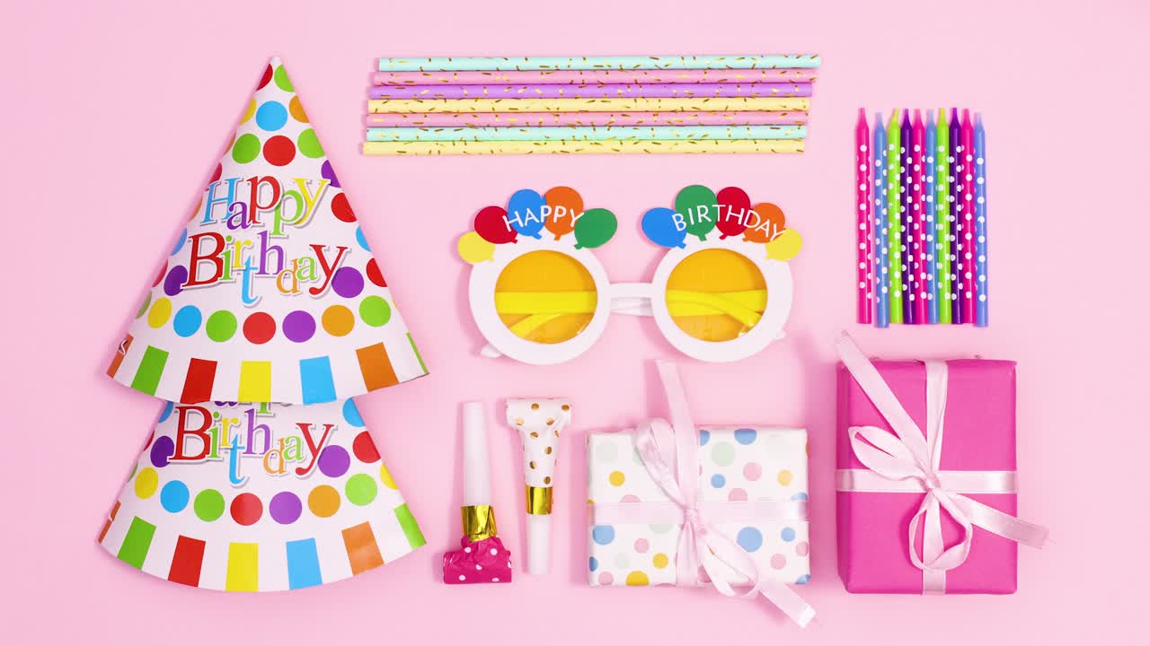 Birthday party layout made of parry accessories and decorations appear on pastel pink theme. Stop motion
