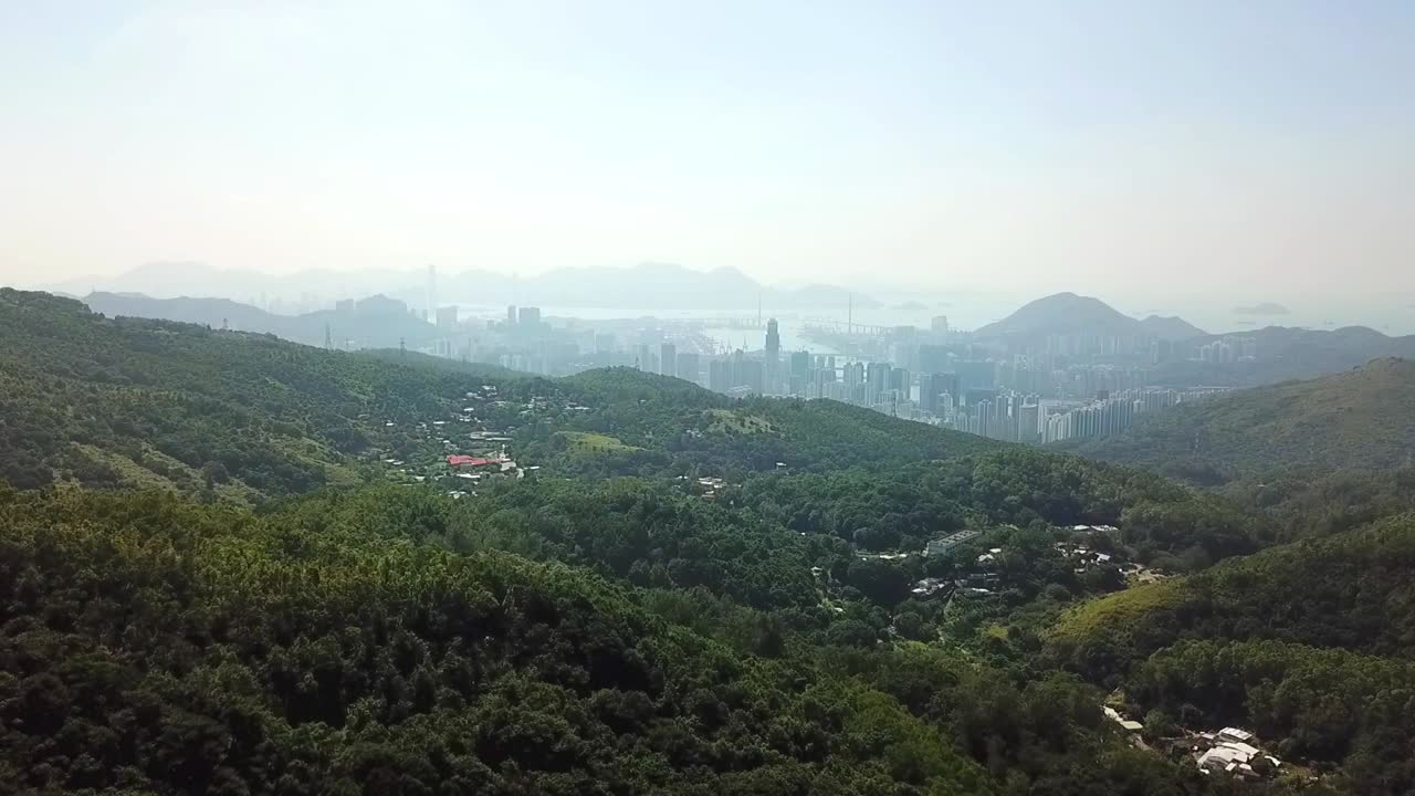 toma aérea, volando desde la jungla a la ajetreada ciudad de hong kong