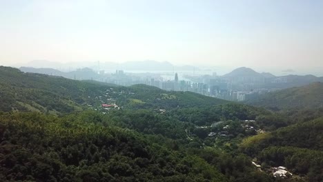 Toma-Aérea,-Volando-Desde-La-Jungla-A-La-Ajetreada-Ciudad-De-Hong-Kong