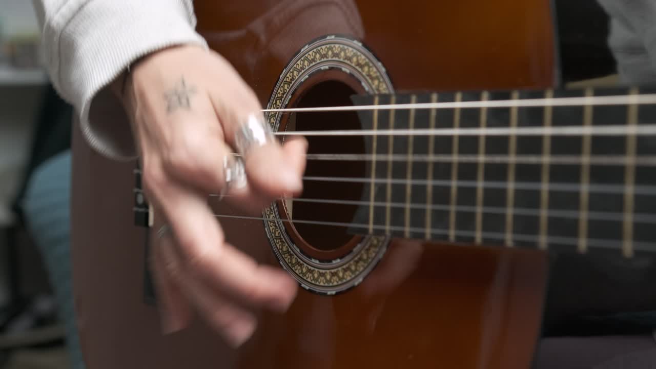 Musician playing acoustic guitar strings