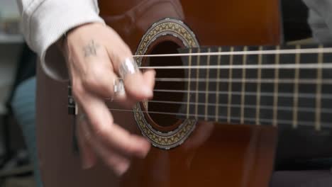 musician playing acoustic guitar strings