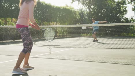 Video-Eines-Glücklichen-Gemischtrassigen-Paares,-Das-Auf-Dem-Platz-Tennis-Spielt