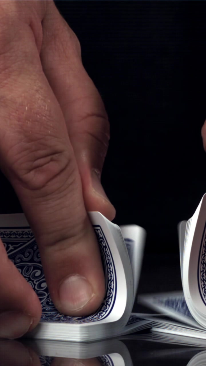 Close-Up of Hands Performing a Riffle Shuffle with Playing Cards