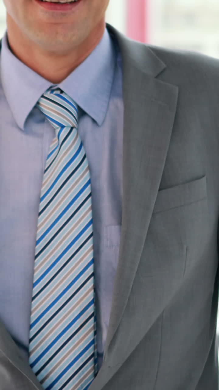 un hombre de negocios feliz mirando a la cámara.