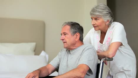 Hombre-En-Silla-De-Ruedas-Viendo-Algo-Con-Una-Mujer