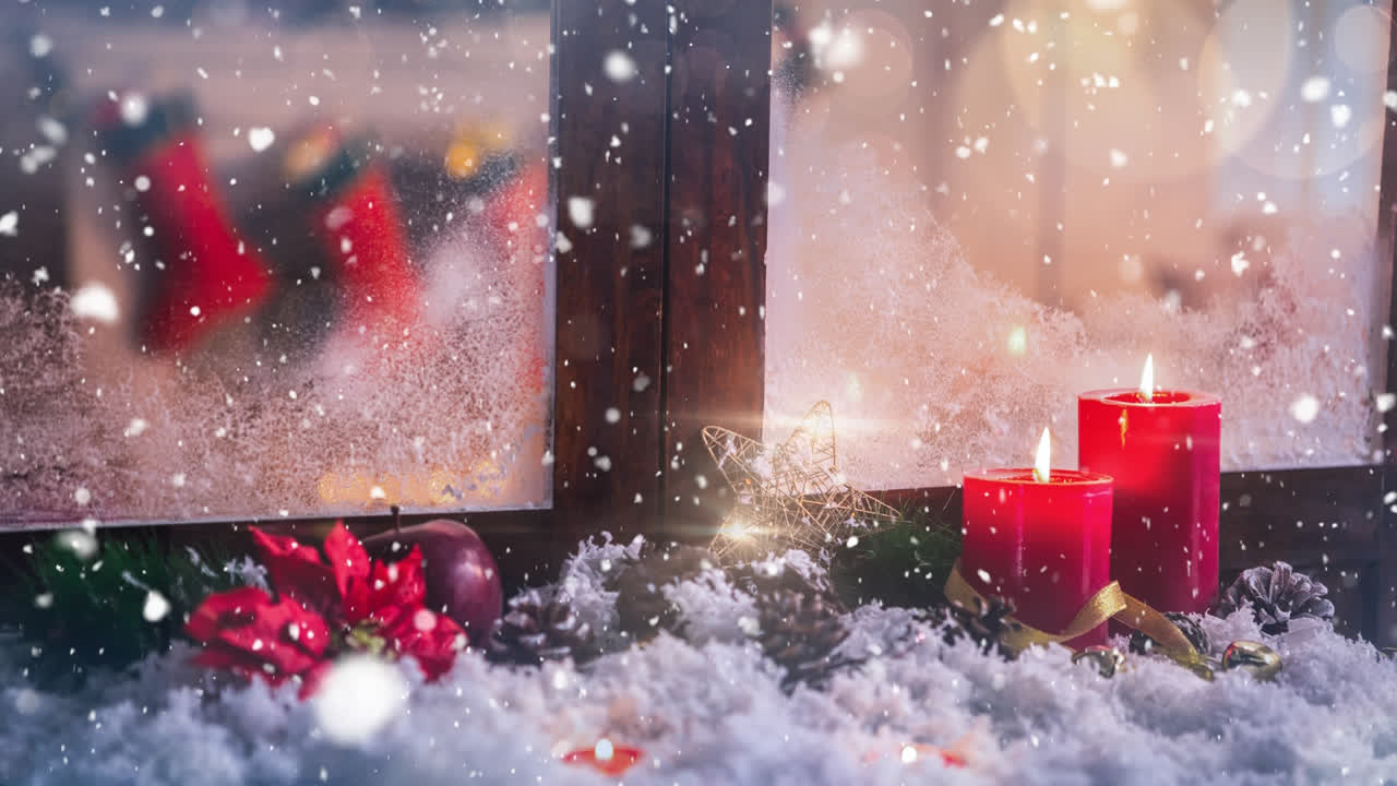 Stearinlys og julepynt uden for et vindue kombineret med faldende sne