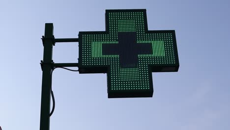 illuminated pharmacy green cross sign exterior