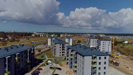 Rückwärtsbewegung-Einer-Luftdrohne-über-Einem-Im-Bau-Befindlichen-Wohnkomplex-Mit-Blick-Auf-Einen-Parkplatz-Im-Zentrum-An-Einem-Wolkentag-Im-Zeitraffer