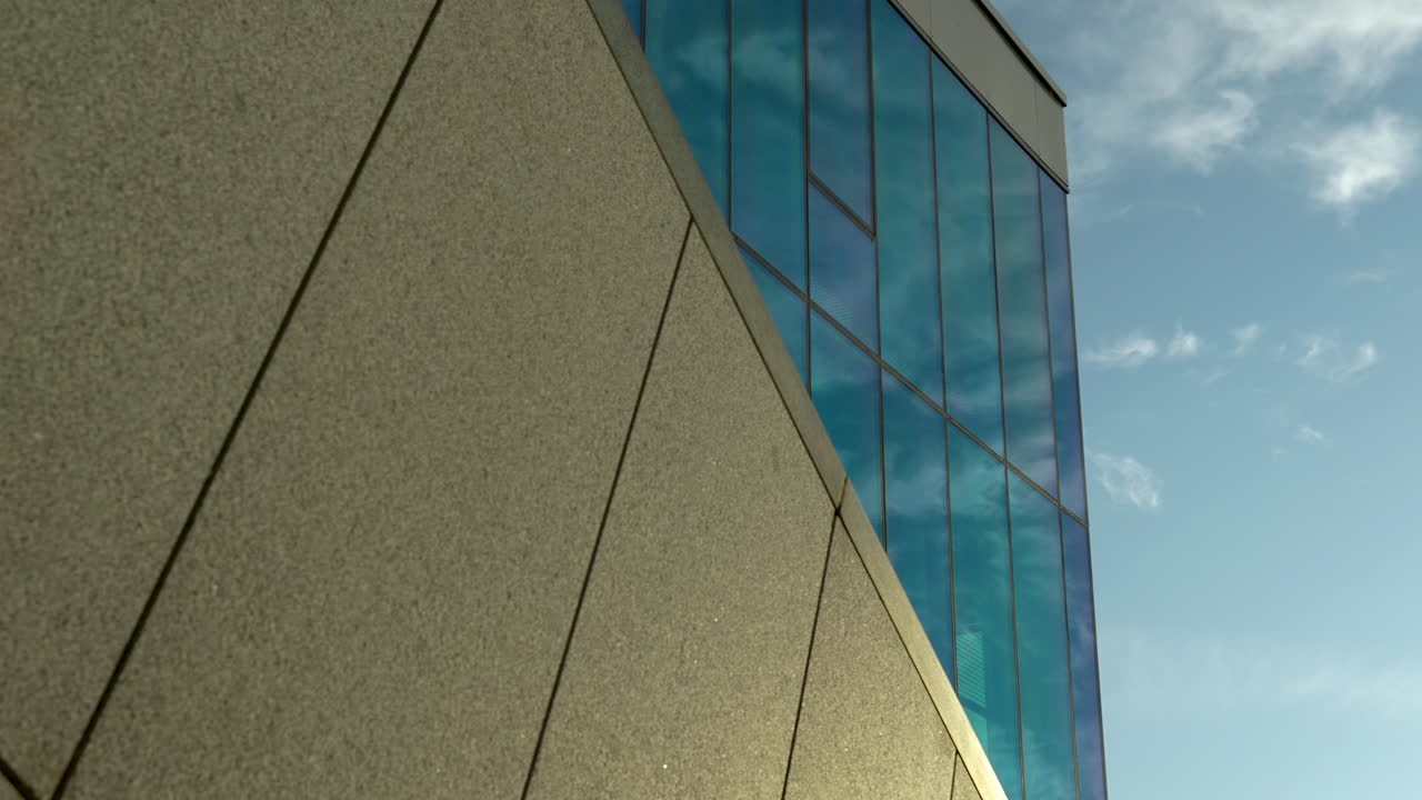 Sunlight casting sharp shadows on a building's angled corner