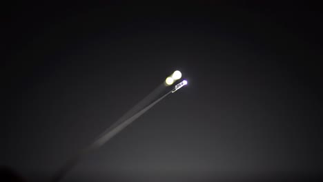 spectators gather to witness an impressive light show featuring bright beams cutting across the dark sky, creating an exhilarating atmosphere. the excitement fills the air as people watch in awe.