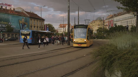 people are waiting for public transport vehicles, hungary, budapest, downtown, szell kalman square ( széll kálmán tér ).