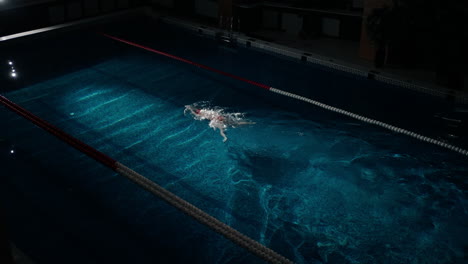 entrenamiento de nadador en una piscina por la noche