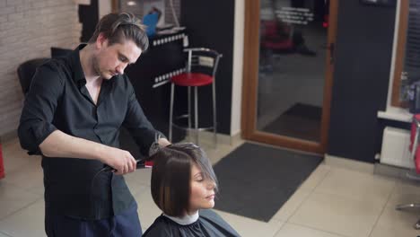 Professioneller-Friseur,-Stylist-Macht-Professionelle-Frisur-Einer-Jungen-Frau-Im-Schönheitsstudio-Und-Verwendet-Haarspange-Zum-Fixieren-Der-Frisur.-Haarglättungs-Schönheits--Und-Haarpflegekonzept