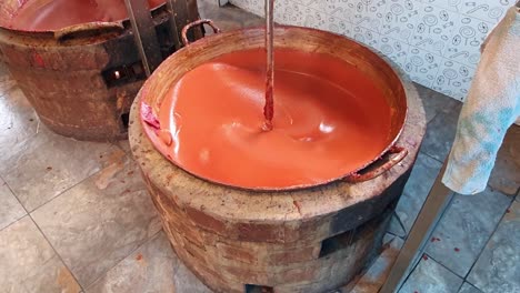 organic farmed healthy fruits are being mixed for traditional guava sweet preparation in a indigenous village in banos ecuador in a big batch