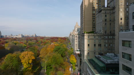 Adelante-Vuelo-Ascendente-A-Lo-Largo-De-Los-Edificios-Que-Rodean-El-Parque.-Hermosos-árboles-De-Color-Otoñal-En-Central-Park.-Manhattan,-Ciudad-De-Nueva-York,-Estados-Unidos