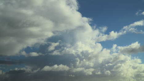 cumulonimbus clouds billowing with darker clouds moving in underneath