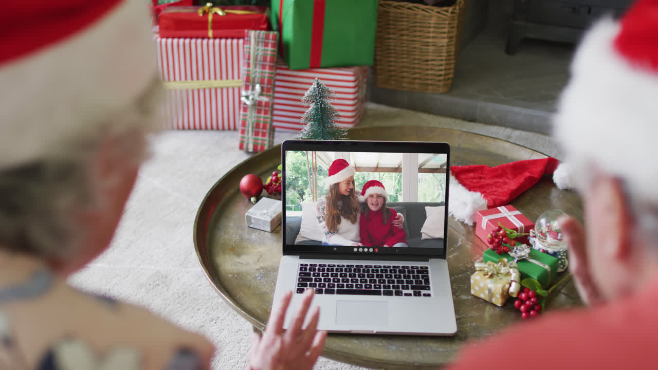 pareja caucásica de alto nivel usando una computadora portátil para una videollamada de navidad con familia feliz en la pantalla