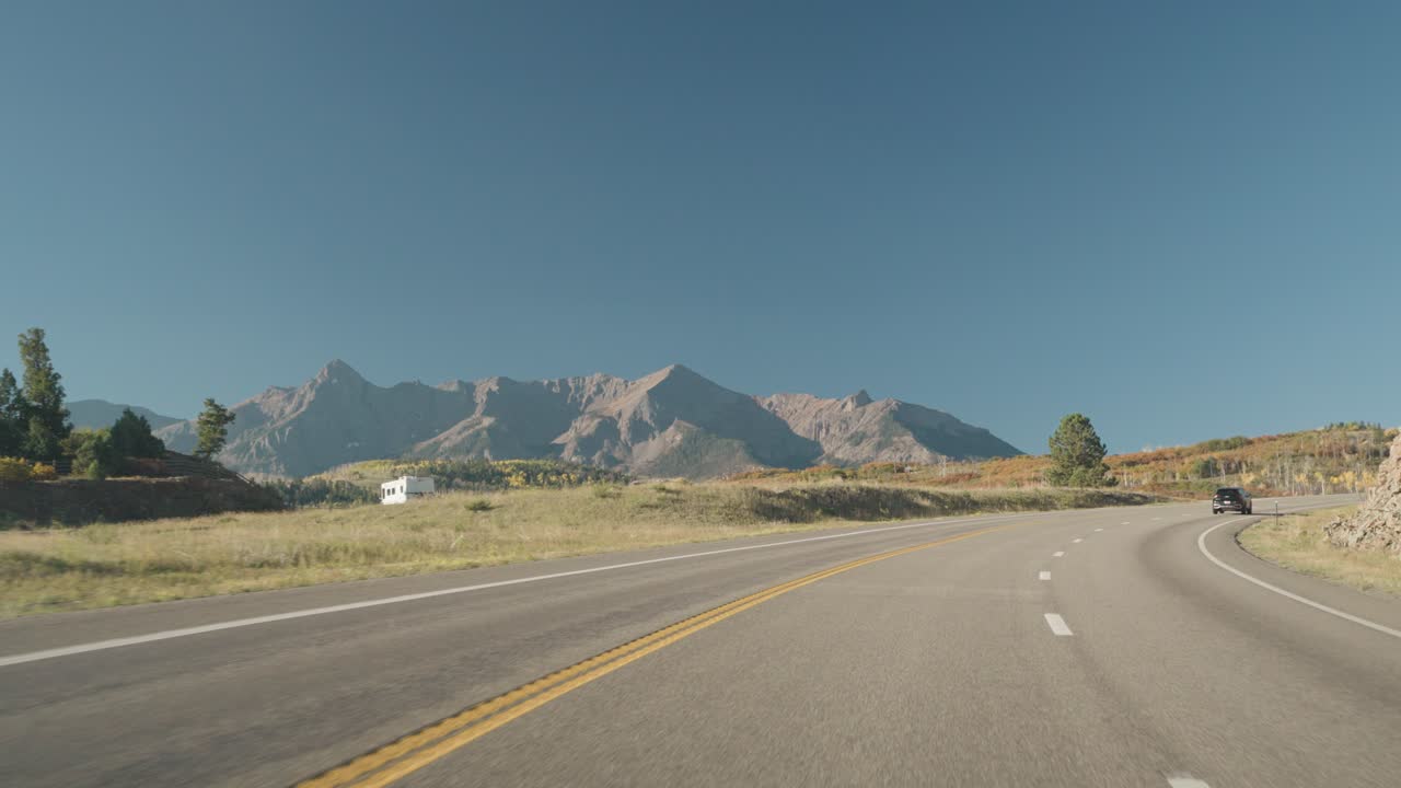 Driving on a scenic road with mountains in the background