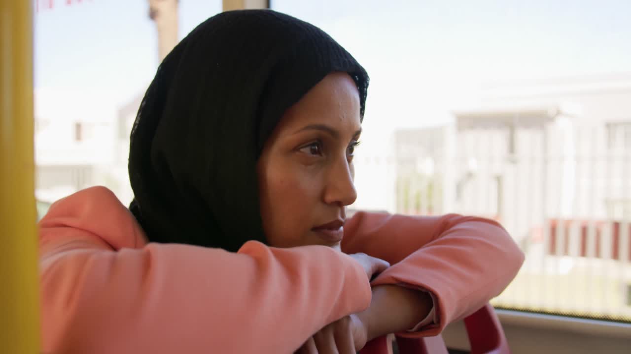 Young woman wearing hijab commuting on a bus