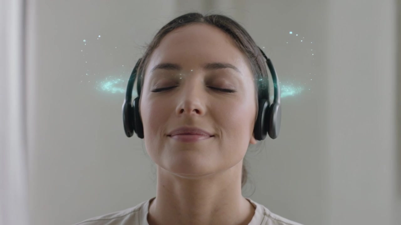 Lyttende kvinde slapper af, mens musik starter derhjemme, iført sorte hovedtelefoner med turkise effekter.