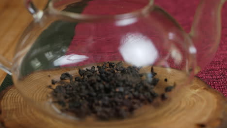 glass teapot with dried black tea leaves