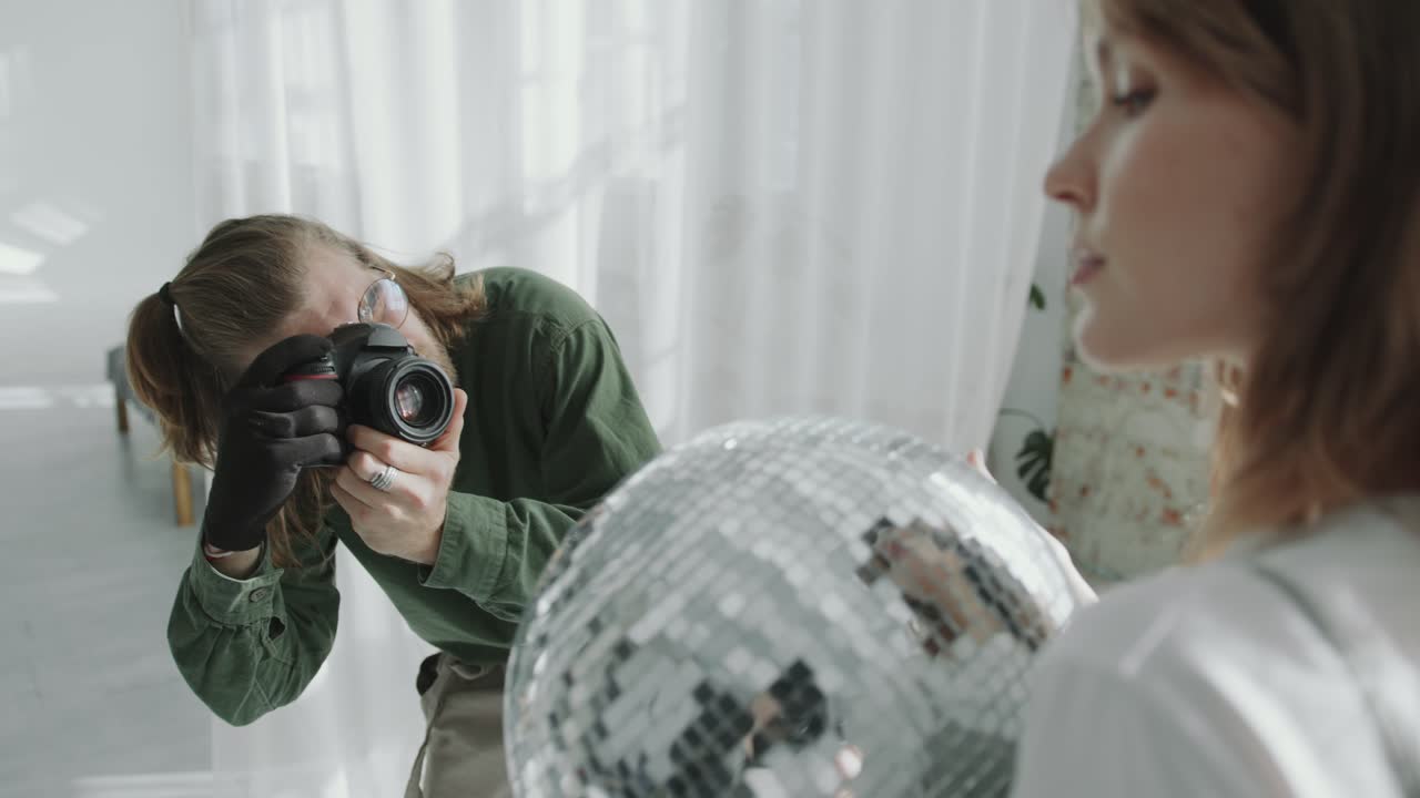 Fashion Photographer Capturing Images of Female Model with Disco Ball