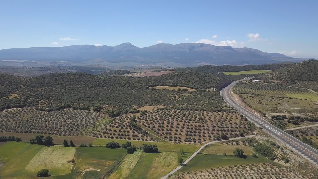 panorámica aérea de una carretera en el sur de españa rodeada de campos de olivos