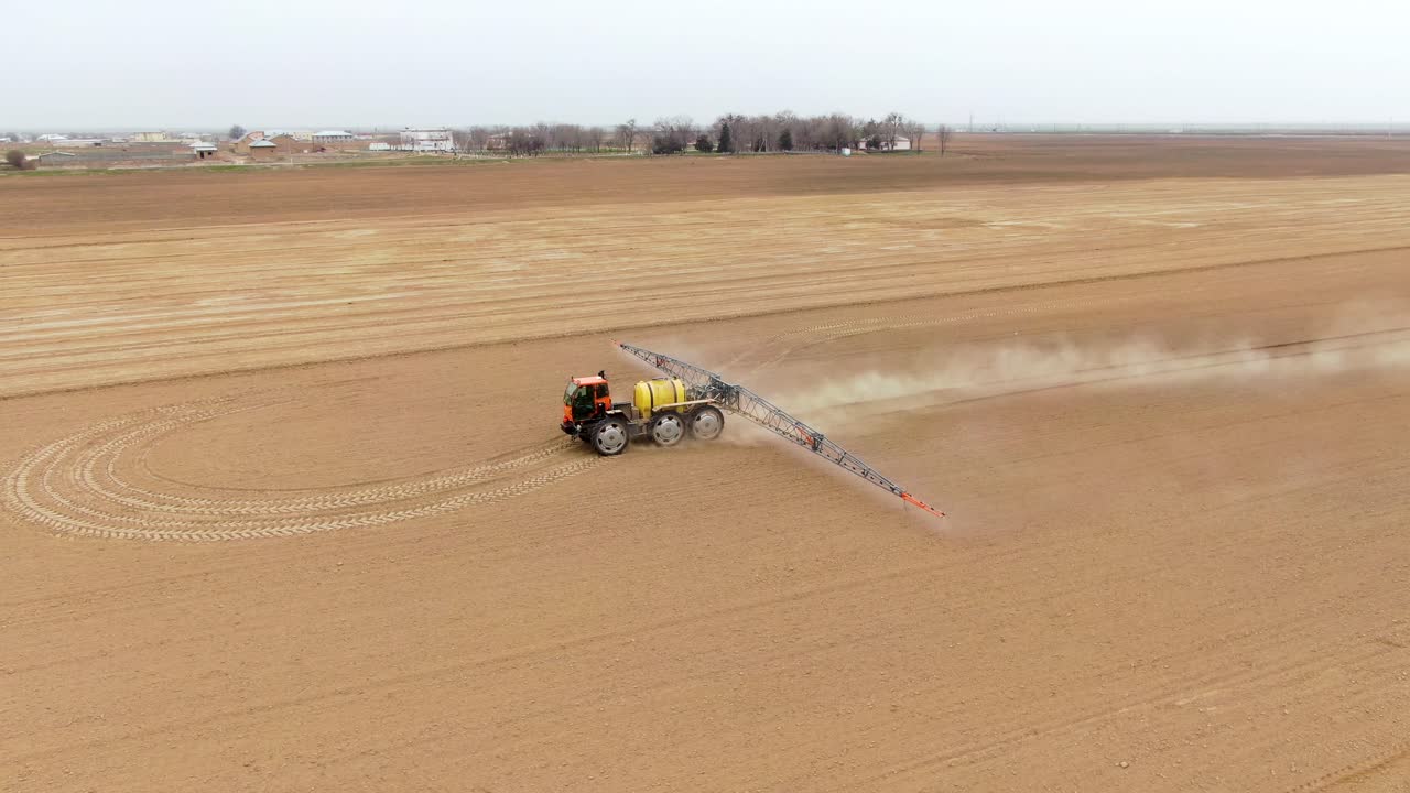 tractor rociando la tierra agrícola con un rociador agrícola montado para pesticidas en el campo