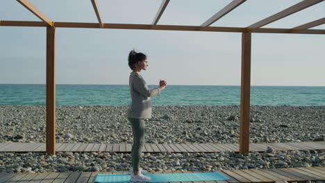 mujer haciendo sentadillas en una playa